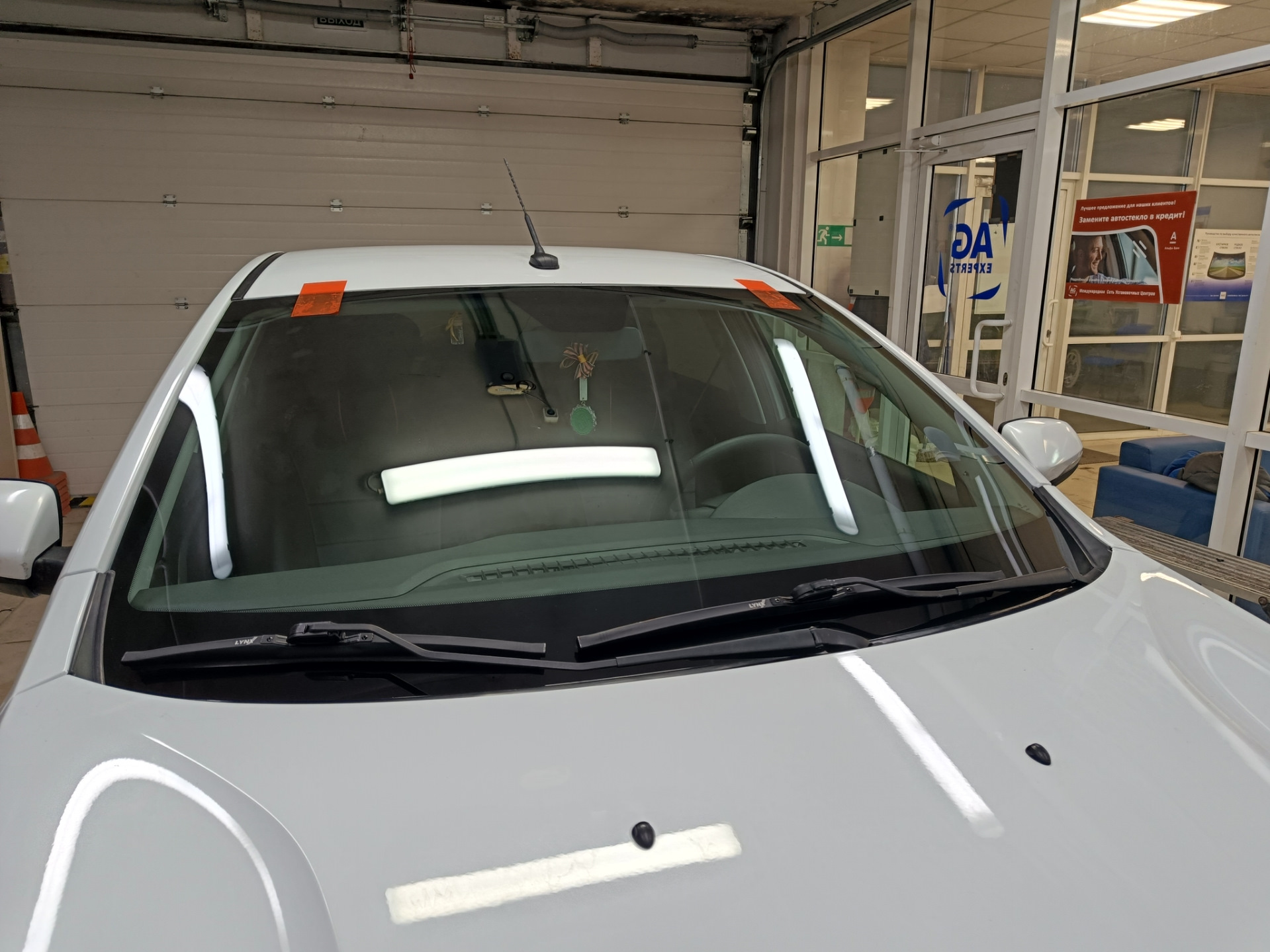 В общем, машина стояла на улице весь ноябрь. Приехал с командировки и утром завёл, а сам пошел домой пить чай пока она грелась. Через пол часа выхожу и вижу, что по всей длине лобовой появилась трещина от небольшого скола — поймал камушек летом, когда ехал на море.

Трещина на всю длину. Стекло SISECAM
Вроде особо и не мешается, но напрягало, что находится на уровне глаз. Так покатался где-то месяц и решил позвонить нескольким фирмам, так сказать узнать цены рынка. Первой фирмой оказалась AG Experts. Цену за стандартное стекло Бор с небольшим затемнением и зелёным оттенком озвучили 7800 рублей. Установка бесплатная. После этого даже звонить не стал другим фирмам, а сразу записался на удобную дату — цена меня устроила. Во время разговора уточнил ещё раз нужную модель стекла с евро-кодом 4592AGS и переспросил точно будет оригинальный Бор, а не какой-то кооператив… Ответили, что будет 100% Бор, который сейчас ставят на конвейер, надо только выбрать вариант его исполнения: с датчиками или без, и т.п. Попросили в день установки заранее заехать на мойку.

А вот и мойка. Прайс — космос для Уфы, одна фаза 600 рублей 🙂 и это только наружка…
После мойки заехал в соседний бокс, где уже весёлые ребята за несколько минут разобрали жабо и сняли старое лобовое.

Старое заводское стекло SISECAM
На фото видно тот самый скол, с которого всё пошло по швам…

Парни срезали лишний герметик и обезжирили поверхность
Видно, что на заводе особо не заморачиваются и наносят герметик так себе. Теперь понятно, почему у некоторых владельцев вода в салоне: на фото можно найти уязвимые места.

Новое стекло установлено. Теперь у нас Бор.
Пол часа и готово!

Стекло ветровое Бор 8450007323 E22 43R-000122 Lamisafe
После того как приклеили, я ещё часик погулял в ближайшем ТЦ пока схватится герметик, вернулся и успел пообщаться с мастерами. Прошло 2 часа и я не спеша поехал домой.

P.s. Парни сказали, что стекла AGS и Бор делают в одном заводе, чему я был удивлён.