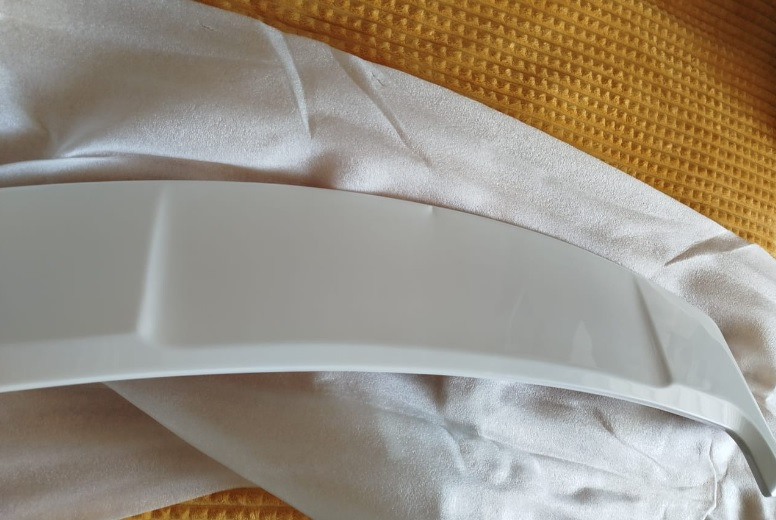 Спойлер — один из немногих элементов стайлинга для Outlander, который вызывает минимум споров — разумеется, с ним лучше, чем без него :)


Со спойлером теперь
Итак, заказал на Али сразу крашеный… По прикидкам некрашеный+покраска (зато точно в цвет) получалась примерно в 15Круб. Окрашеный сразу в белый — 4,3Круб. Решил рискнуть.

Пришел спойлер в транспортную компанию упакованный в пузырчатую пленку основательно, как мумия :)
И, тем не менее — сурпрыз! Заметный залом на внешнем ребре :(


Ну как так?
Ну в той 10-сантиметровой толщины обертке вряд ли так могло получиться, скорее всего сразу таким положили.
В-общем, подал спор (изначально подумал, что оспоренный деньги отдам мастерам, чтобы шпатлевали и красили). Отспорил 1,8Круб. То есть спойлер с дефектом обошелся в 2,5Круб.


По цвету — очень хорошее попадание, разве что на спойлере есть примесь блестящая (наверное, это Polar White или как его там). Но с завода бампера от кузова отличаются существенно сильнее :)
Уже начал у знакомых спрашивать, кто занимается такими работами, никто не признавался… повертел-покрутил в руках и решил кое-что попробовать :)

Сделал технологическое отверстие на внутренней стороне, обмотал изолентой наконечник длинной отвертки, нагрел спойлер в теплой воде, арендовал у жены фен и поставил его на минимальный нагрев.
Ну и изнутри минут за 30 осторожненько выровнял дефект.


Технологическое отверстие и инструмент
Пару недель спойлер отлежался на балконе (проверил, не сработает ли эффект памяти у пластика, когда остынет). Дефект проявился прям минимально (и то, это я знал, куда смотреть). Еще минут 10 повторил процедуру поддавливания и нагрева — и вуаля! Результат отличный.


Живьем вообще место дефекта не найдешь
Следующим квестом оказалось прикрепление.
Дальнейший текст скорее всего будет более интересен ростовчанам…

Беглый поиск стекольного герметика и праймера показал, что это добро обойдется в пару тысяч, не меньше. И потом почти весь герметик все равно на выброс…
Заехал в пару мест, где устанавливают стекла. В одном (федеральная сетка, АвтоТрейд) сразу сказали, что у них нет такой услуги в прайсе, а "внепрайсовые работы" караются штрафом и вплоть до увольнения. Но общались вежливо.

В другом (с довольно живыми социальными сетями, вроде как позиционирующие себя положительно, Автостекла на Вавилова) — просто вышел чувак, ни здрасте, ни досвидания, просто сказал "нет, я это делать не буду" и развернулся. Резкий контраст с социальными сетями. Неприятный осадочек :)

Уже подумал — ну всё, придется самому материалы покупать и звать кого-нибудь на помощь для ровной установки. Но решил заглянуть к еще одним установщикам автостекол. Оказалось, неподалеку есть AG Experts. Ребята красавчики — и пообщались вежливо, и один парень вышел посмотрел-пощупал спойлер. Согласились сделать. Подошли прям очень профессионально — все обезжирили, нанесли праймер, погрели феном и спойлер и крышку багажника, нанесли герметик, приклеили спойлер. И стоимость услуги нормальная — 1,5Круб.


Кепка
В-общем, теперь Белый Бумбр со спойлером.
Считаю, что он делает внешний вид аута существенно гармоничнее. Плюс стоимость доработки получилась ну очень приятной.